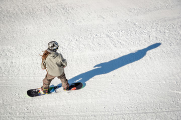 Fototapeta na wymiar Photo of a snowboarder taken from above. Snowboarder and his shadow