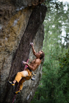 Extreme sport climbing. Young male rock climber on a rock wall.