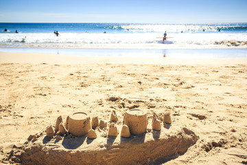Sand castle and surfers, Sagres, Algarve, Portugal