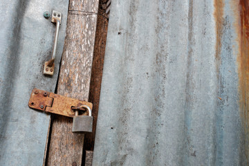 Old rusty padlock on old rusty iron door.