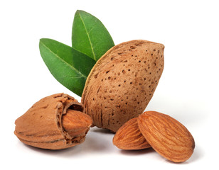 almonds in their skins and peeled with leaf isolated on white background