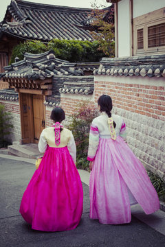 A couple women wander through the traditional style houses of Bukchon Hanok Village in Seoul, South Korea.