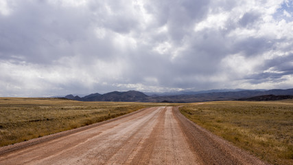 Fototapeta na wymiar Road Through a Colorado Valley with Mountains in the Background