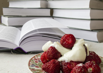deser truskawkowy z bitą śmietaną na tle książek, Strawberries on the background of books