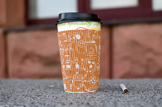 Cigarette next to plastic cup