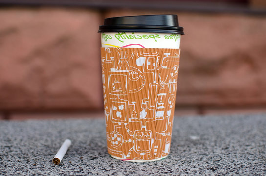 Cigarette next to plastic cup