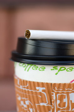 Cigarette next to plastic cup