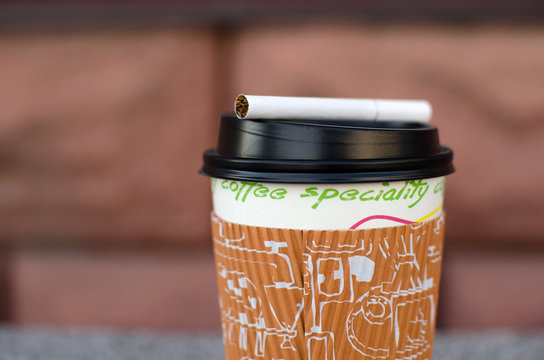 Cigarette next to plastic cup