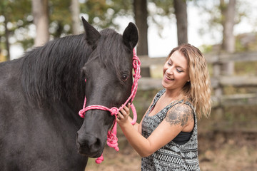 Woman holding a black horse