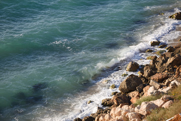 Wild beach with yellow stones and clear sea