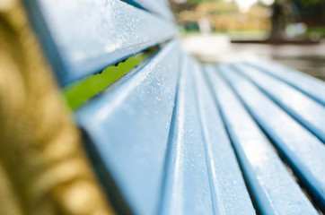 Close up of wet blue bench 