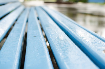 Close up of wet blue bench 