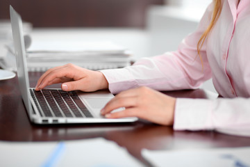 Close up of business woman hands typing on laptop computer