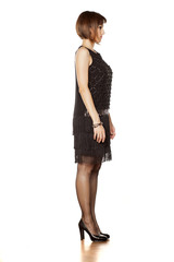 full figure of middle aged woman in short black dress. side view