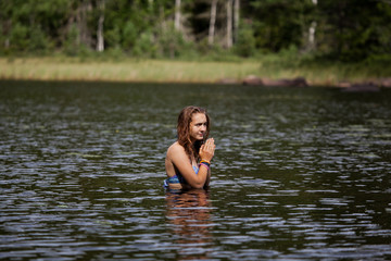 Girl preparing to dive in a Swedish lake surrounded by dense pin