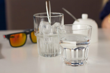 eye glasses and twoglasses of water on the table