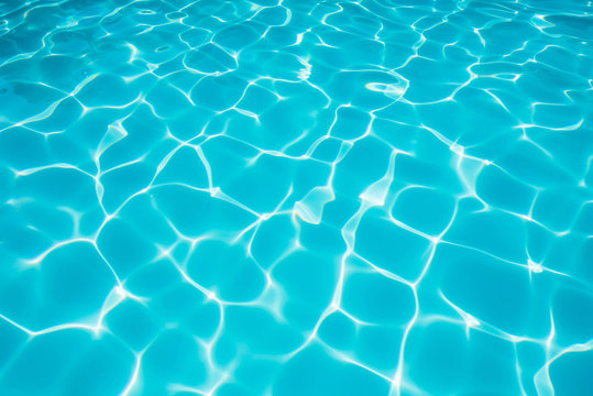 Ripple blue water in swimming pool witn sun reflection
