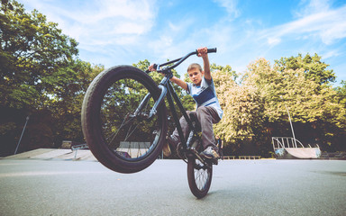 Boy riding a bmx in a park.