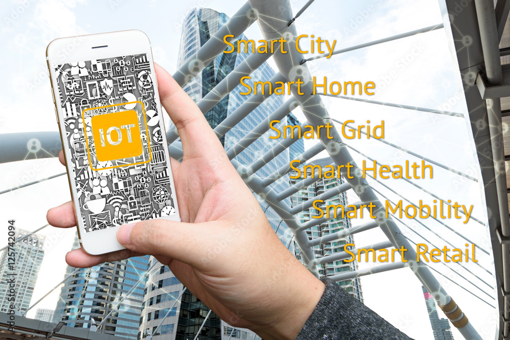Poster internet of things concept .man hand holding smartphone and iot text with building background
