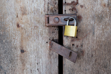Old rusty padlock on old wooden door.