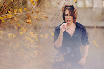 Молодая красивая женщина в черном пальто стоит возле...