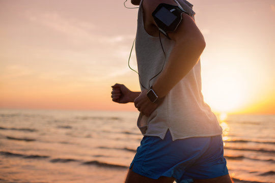 Man running on the beach with modern technology