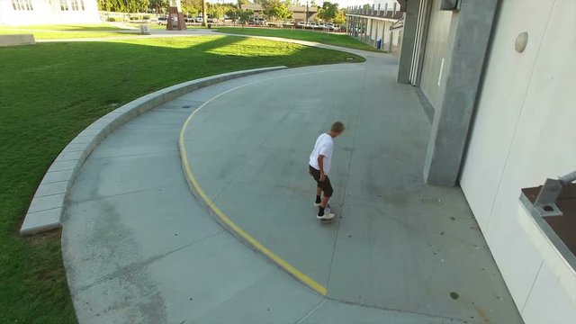 This is a Aerial video taken with a drone of a Big Jump Over Stairs by a teenage male Skateboarder