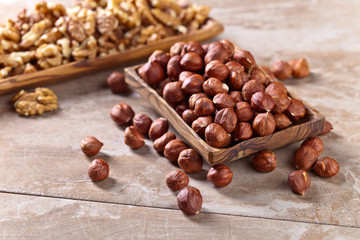 Hazelnuts and walnuts in old wooden dish