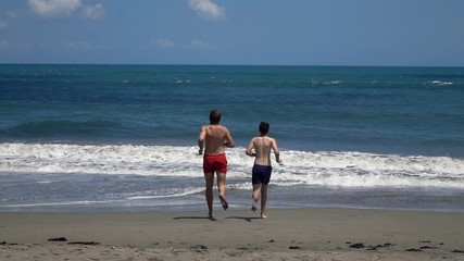 Father with son running towards sea, super slow motion 240fps
