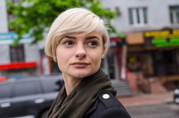 Young blonde girl walking on the city