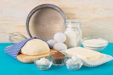 Ingredients for the dough. The finished dough. On a blue and wooden background.