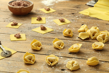 pasta fresca fatta a mano tortellini ripieni su tavolo di cucina rustico
