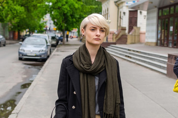 Young blonde girl walking on the city