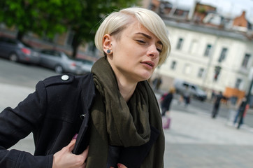 Young blonde girl walking on the city