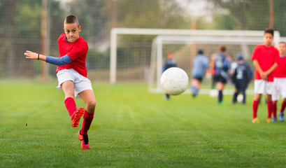 Obraz premium Boy Shooting at Goal