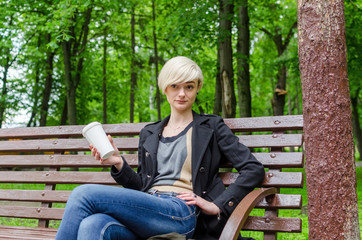 Obraz premium Young girl with a plastic cup of coffee