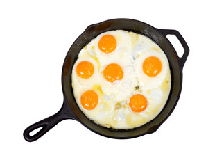 Fried eggs on cast iron skillet with salt isolated on white background