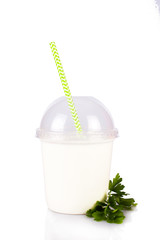 Yogurt, kefir, smoothies, mousse in a plastic cup with a straw, with parsley. On white, isolated background.