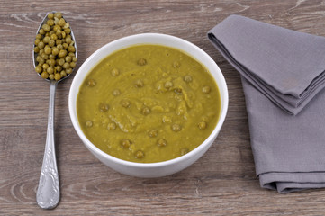 Bol de soupe aux petits pois avec une cuillère de petits pois