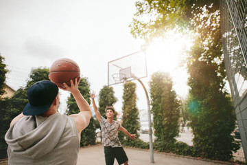 Naklejka premium Streetball players on court playing basketball.