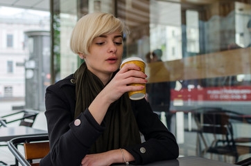 Young girl with a plastic cup of coffee