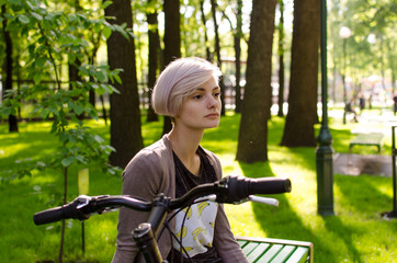 Naklejka premium Young girl with bicycle in the park