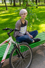 Fototapeta na wymiar Young girl with bicycle in the park