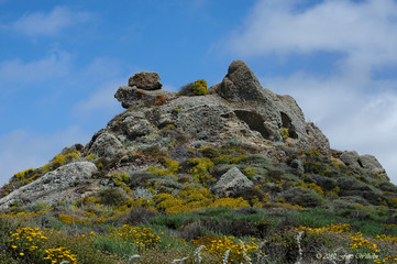 Dramatic rock formation in front of white clouds blue sky