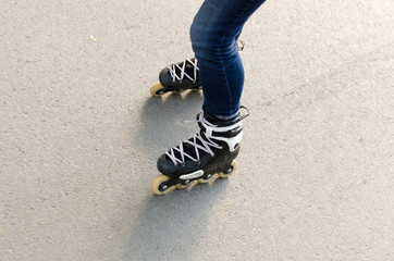 Naklejka premium Young girl with rollers in the park