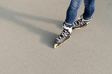 Naklejka premium Young girl with rollers in the park