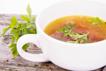 Chicken soup with carrots and parsley on wooden background