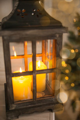 New Year or Christmas lantern with candles on the background lights Christmas tree and gifts