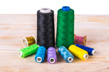 Different sewing thread. On a wooden background.