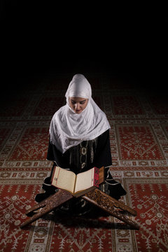 Muslim Woman With Hijab reading Koran